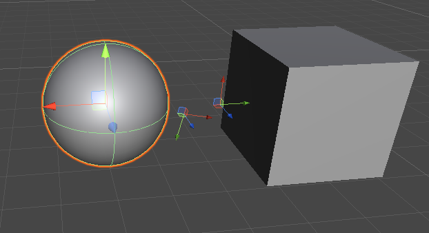 A sphere and cube in the Unity Editor with scaled transform tools.